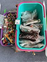Photo showing plastic storage bins filled with various organized cross stitch threads, small bags, and supplies.