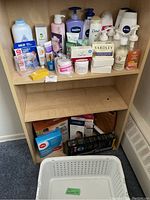 Photo of wooden shelf with assorted personal care products including lotions, soaps, powders, band aids, and wellness aids.