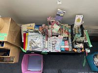 Overhead view of the entire craft supplies lot with storage boxes, various craft materials, and metal chest of drawers.