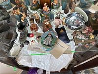 Overview of collectibles including Sound of Music music box, figurines, roller skate, shoe statue, decorative plate, and various figure decorations on display.