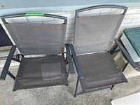 Photo of two metal frame folding chairs with grey nylon seats and backs, showing the upright chairs.