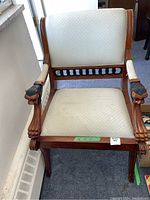 Front view of the occasional chair showing wood frame and cream upholstery with diamond pattern.