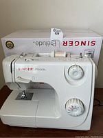Singer Prélude Model 8280 sewing machine in white with original box behind it.