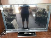 Full frontal view of the Sony Bravia 40-inch TV showing the screen, bezel, and stand with remote placed on the stand base.