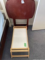 Folding breakfast-in-bed tray with light wood frame, white insert surface, foldable legs shown upright