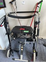 Full view of walker showing padded seat, back support strap, mesh basket underneath, cane, and grabber hanging on walker frame