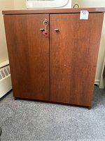 Front view of the wooden cupboard, showcasing the two door panels and the overall size and finish.