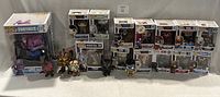 Photo showing 19 Funko collectible figures including boxed and loose items from Fortnite, Resident Evil, Ghostbusters, and others.