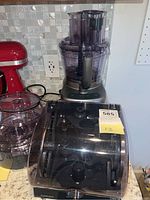 Front view of Cuisinart food processor with dicing kit in closed case and separate bowl on countertop.