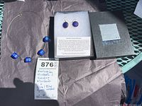 Full lot showing necklace, earrings in box, and label describing jewelry and artist