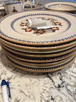 Stack of 8 floral patterned plates showing design and condition