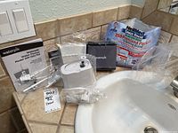 Waterpik Water Flosser model WP-150/152, power cord, manual, accessories with open bag of NeilMed Sinus Rinse packets on bathroom counter.