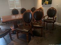 Group view of four chairs set around a dining table showing one armchair and three side chairs