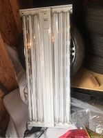 Top view of the greenhouse ceiling lamp showing eight fluorescent tubes mounted in a metal frame with visible price tag.