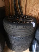 Stack of 3 tires mounted on Chrysler rims, showing sidewall and tread of tires.