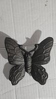Front view of cast iron butterfly decor showing detailed wings and body.
