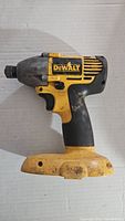 Side profile of Dewalt DW056 impact driver showing yellow and black casing with signs of wear and no battery attached