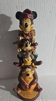 Front view of Disney Wilderness Lodge totem pole figurine featuring Mickey Mouse, Goofy, Donald Duck, and Pluto stacked vertically.