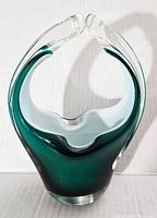 Front view of green and clear hand blown art glass basket with split handle and white frosted inner detail