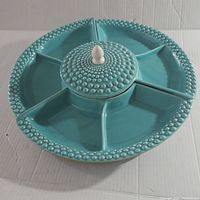 Top view of the turquoise ceramic Lazy Susan showing hobnail detailing on rim and central knob, with five segmented compartments.