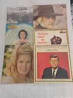 Top view showing six vinyl record album covers including Tom T. Hall, Charlie Rich, Larry Gatlin, Rainbow Round My Shoulder, and John Fitzgerald Kennedy Memorial album.