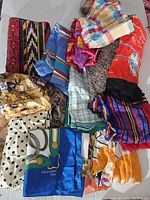 Lot of vintage women's scarves in various colors and patterns, including striped, polka dots, florals, and abstract designs.