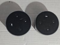 Top view of two Amazon Echo Dot devices showing buttons for volume control, microphone off and action button.
