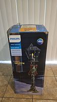 Box of Philips Glitter Lamp Post showing packaging with product name and features including LED light and twinkling effect.