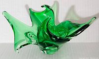 Green art glass bowl with 6 spread arms, showcased from an angle highlighting shape and form.