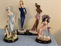 Wide shot showing all four porcelain Natelia Collection ladies figurines together on display, detailed view of styles and poses.