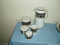 Full set of Mikasa Intaglio Arabella including coffee urn, tea pot, creamer, sugar container with lid, and honey jar all displaying the purple floral band