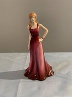 Front view of the Royal Doulton Laura porcelain figurine in deep red evening gown, showing detailed sculpting and finish.