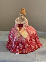 Front view of Royal Doulton Victoria porcelain figurine showing detailed face and pink floral dress holding a fan