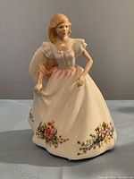 Front view of the Royal Doulton Joanne figurine showing woman in white floral dress with pink sash.