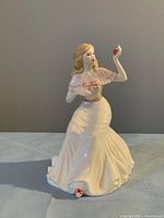 Front view of the Royal Doulton figurine showing the woman in white dress holding an apple.