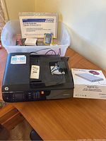Image showing HP Office Jet 4630 printer with accessories including calculator, Oxford file guide set in a plastic bin, battery backup box, and cords.