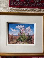 Framed landscape painting showing trees and sky with clouds, signed by artist.