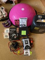 Full lot overview showing pink Bosu ball, dumbbells, shredder, and automobile accessories