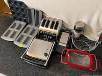 Overview of all kitchen items including the panini press, Breville toaster, bakeware, strainer, grater, and fruit bowl