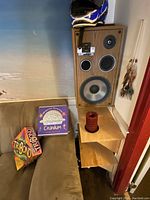 Speaker standing vertically showing wood grain cabinet, multiple drivers including woofer, midrange and tweeter, control knob labeled for high range, and model label "Dynamic Audio Pro Poly Series 1901".