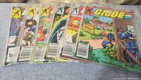 Six G.I. Joe comics in plastic sleeves laid out side by side, showing varying cover art and issue numbers.