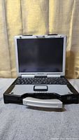 Front view of Panasonic Toughbook CF-29 laptop with screen open showing keyboard and built-in touchpad with handle at front.
