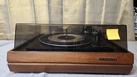 Front view of vintage Panasonic turntable with wood exterior and clear dust cover closed.