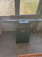 Front view of the 6 inch jointer showing metal table with minor surface rust and green painted base unit.