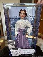 Front view of Barbie Helen Keller doll in original packaging, showcasing the doll and background imagery with label.