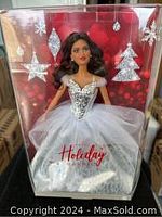 Front view of 2021 Holiday Barbie doll in box with holiday-themed background and silver dress.