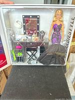 View of unopened set in original display packaging showing Barbie doll in gown, vanity desk, stool, makeup pieces and accessories