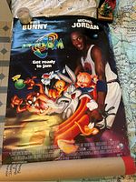 Photo of Space Jam movie poster featuring Michael Jordan and Looney Tunes characters in front of a dark, cosmic background.