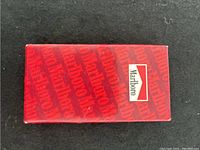 Top view of the Marlboro-branded red box with printed Marlboro text and central logo.
