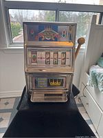 Front view of the Casino Crown slot machine showing the coin slot, rotating reels with fruit images, payout schedule panel and lever on the right side.